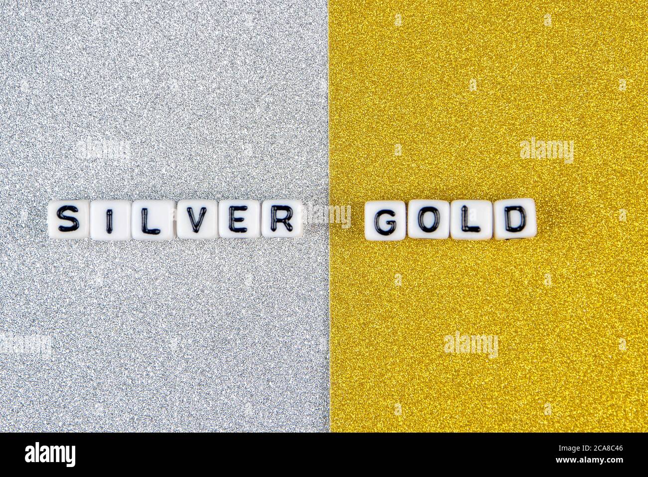 mots en argent et or formés de dés blancs avec des lettres noires sur fond argenté et doré, image divisée en deux moitiés Banque D'Images