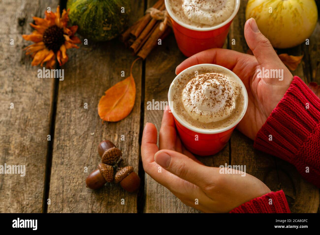 Latte épicée de citrouille dans des verres orange sur fond de bois Banque D'Images