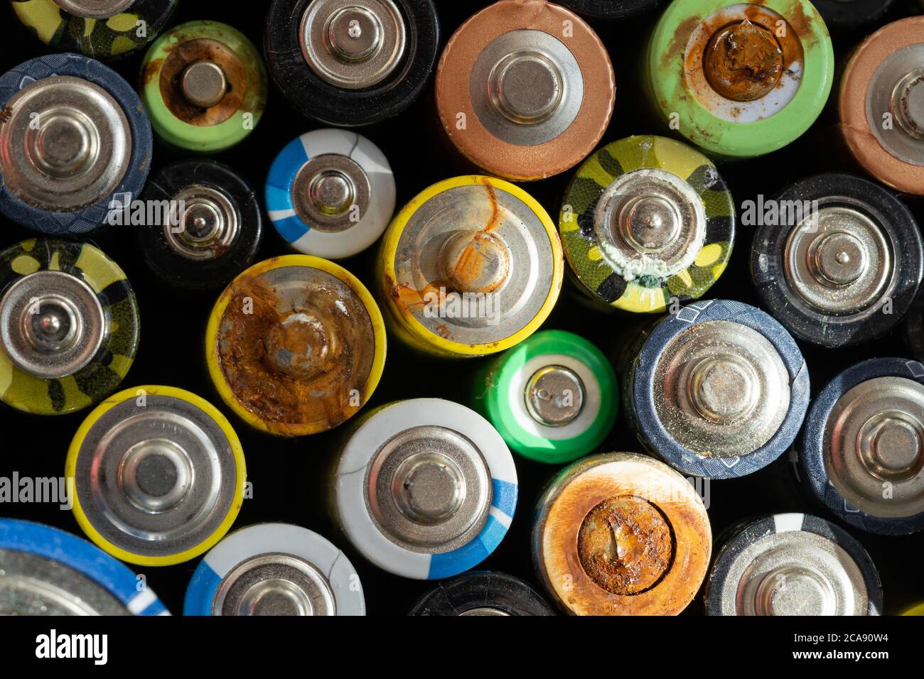 Gros plan des extrémités positives des batteries déchargées de différentes tailles et formats, mise au point sélective. Batterie usagée corrodée et rouillée. Risque d'accident Banque D'Images