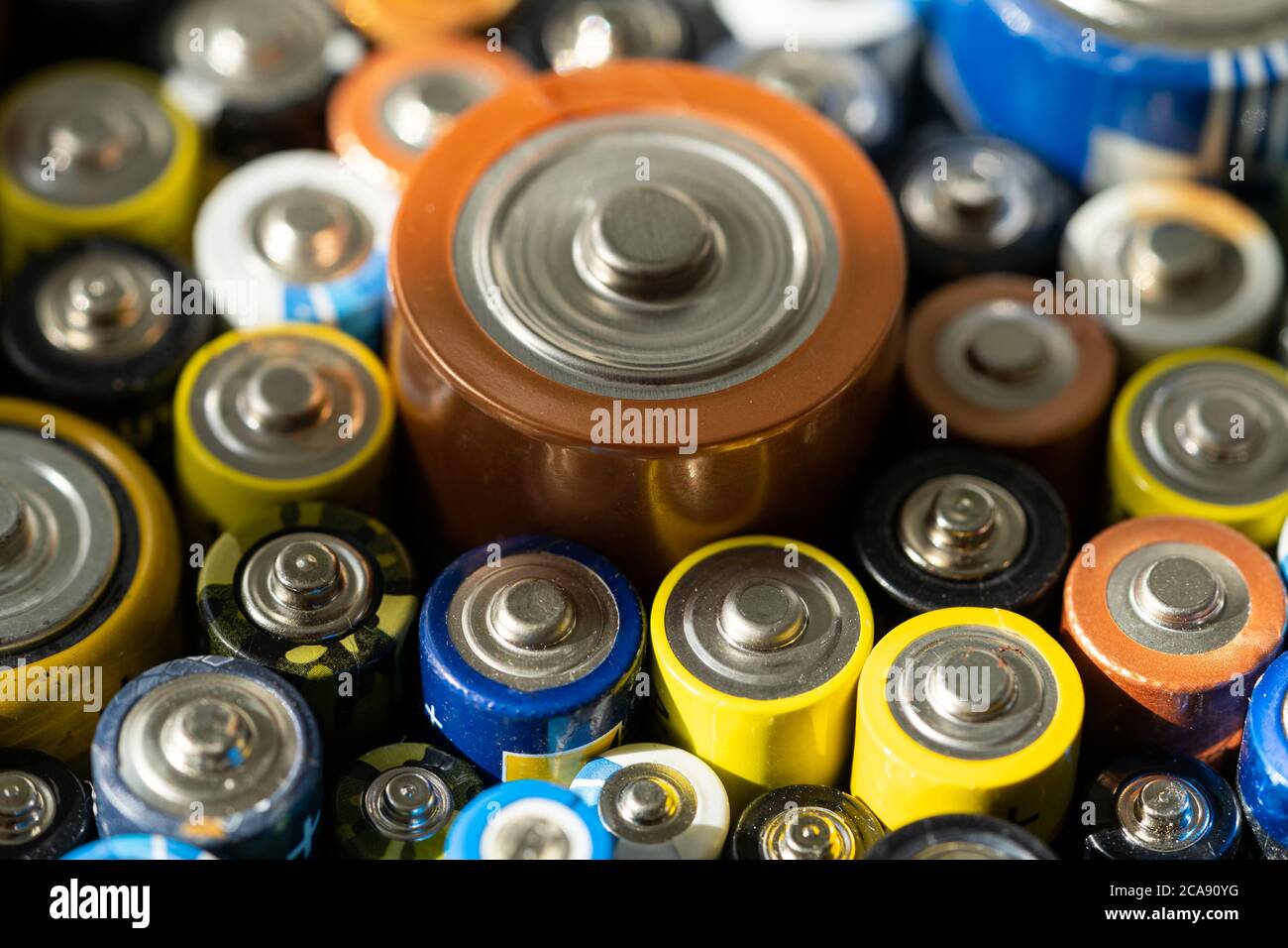 Gros plan des extrémités positives des batteries déchargées de différentes tailles et formats, mise au point sélective. Batterie usagée pour recyclage. Produit pour déchets dangereux Banque D'Images