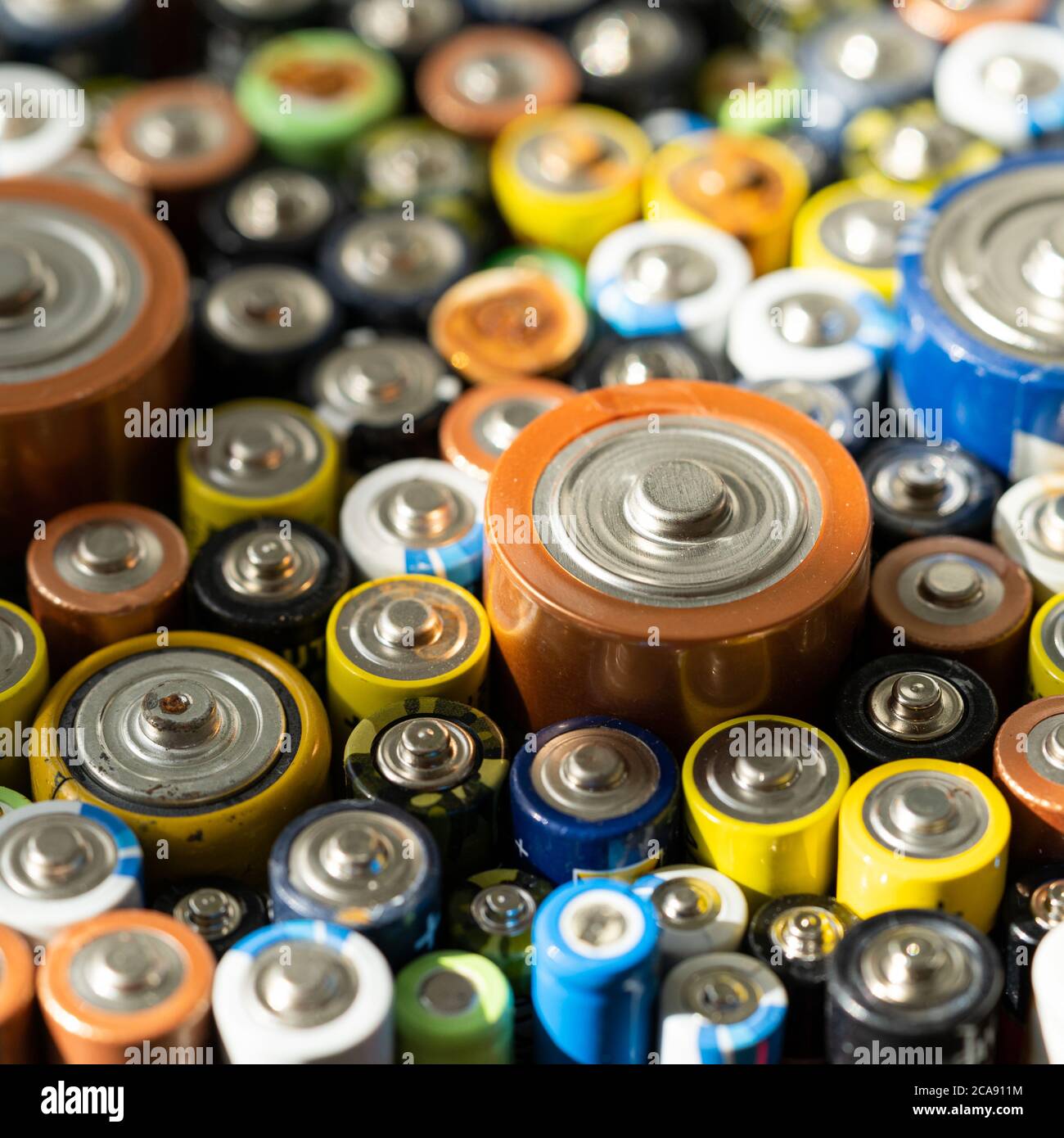 Gros plan des extrémités positives des batteries déchargées, mise au point sélective, photo macro. Pile alcaline usagée corrodée et rouillée. Déchets dangereux conc Banque D'Images