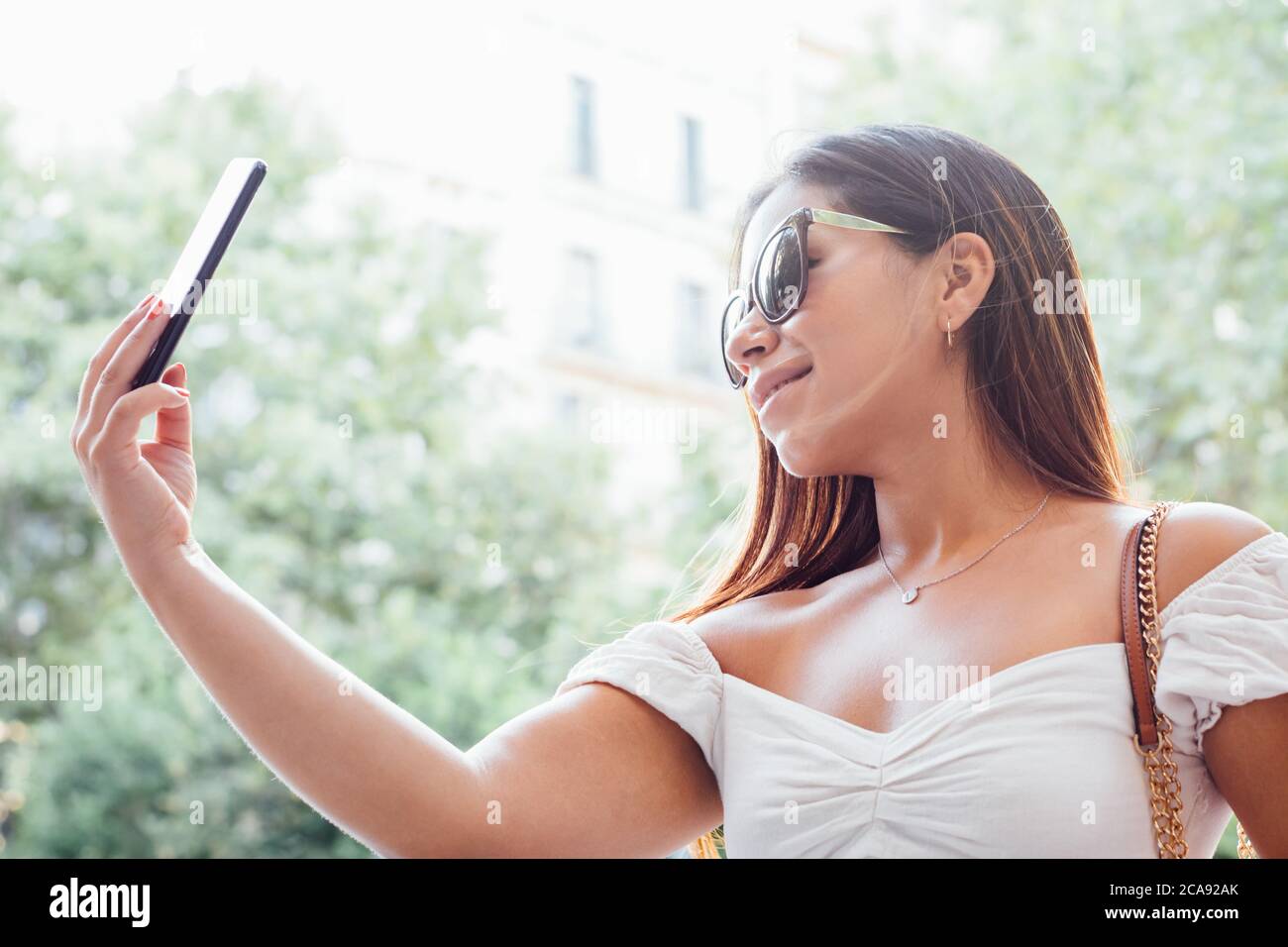 femme prenant un selfie avec son smartphone Banque D'Images