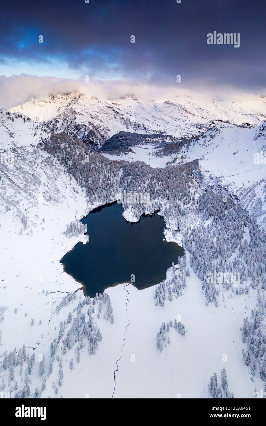 Lac Cavloc entouré de neige, vue aérienne, vallée de Bregaglia, Engadine, canton de Graubunden, Suisse, Europe Banque D'Images