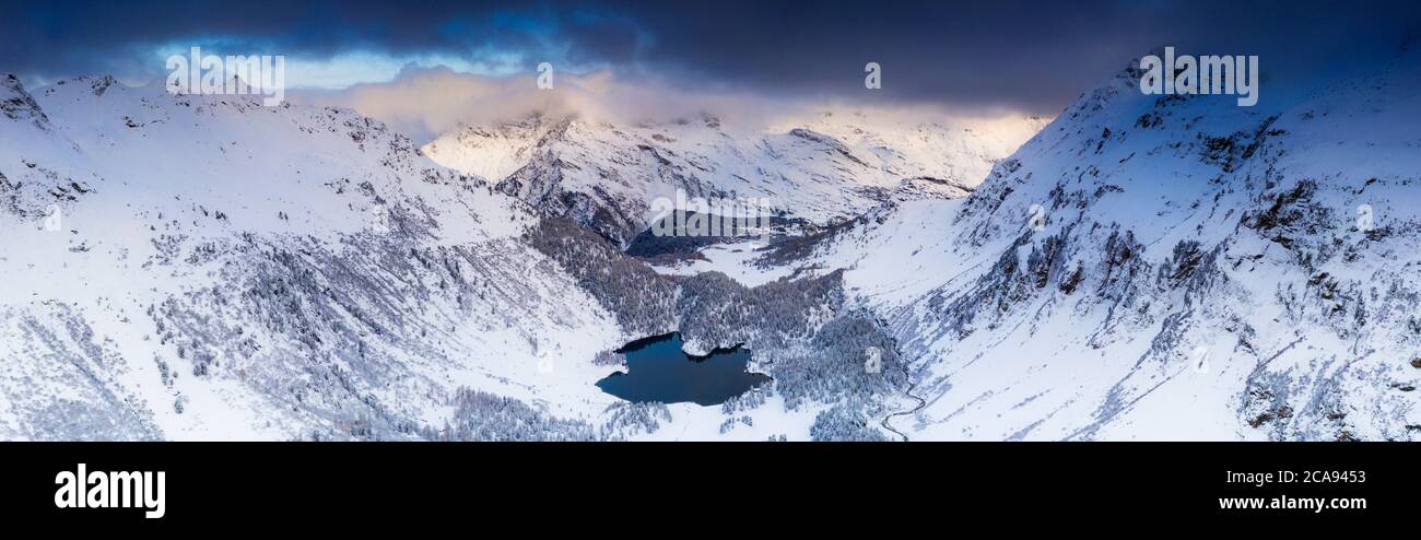 Vue panoramique aérienne du lac Cavloc et des forêts enneigées, vallée de Bregaglia, Engadine, canton de Graubunden, Suisse, Europe Banque D'Images