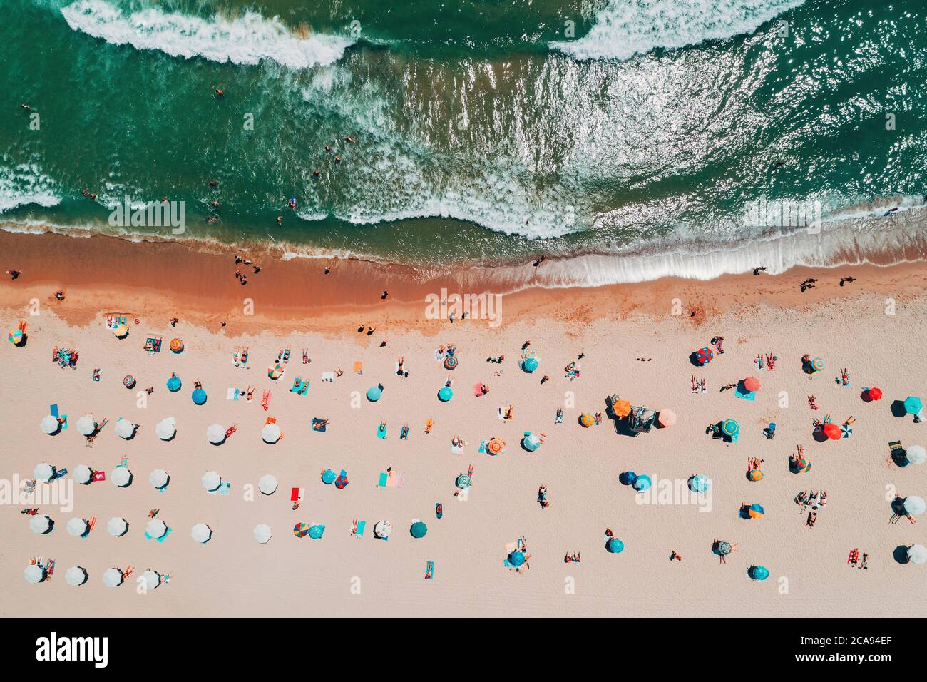 Vue de dessus de l'antenne sur la plage. Parapluies, le sable et les vagues de la mer Banque D'Images