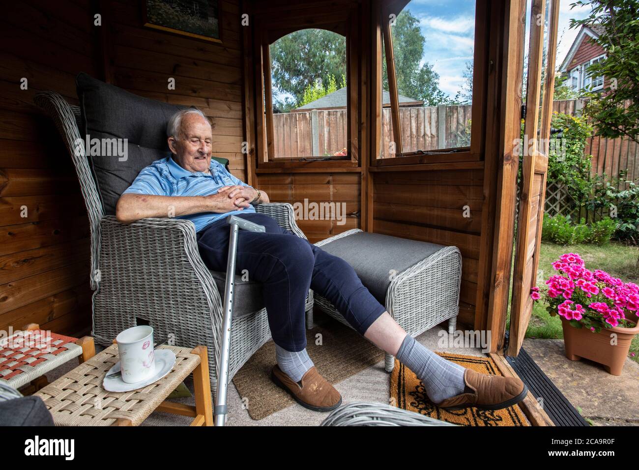 Couple de personnes âgées dans leurs années 80 appréciant le temps chaud d'été dans leur jardin d'été maison, Angleterre, Royaume-Uni Banque D'Images