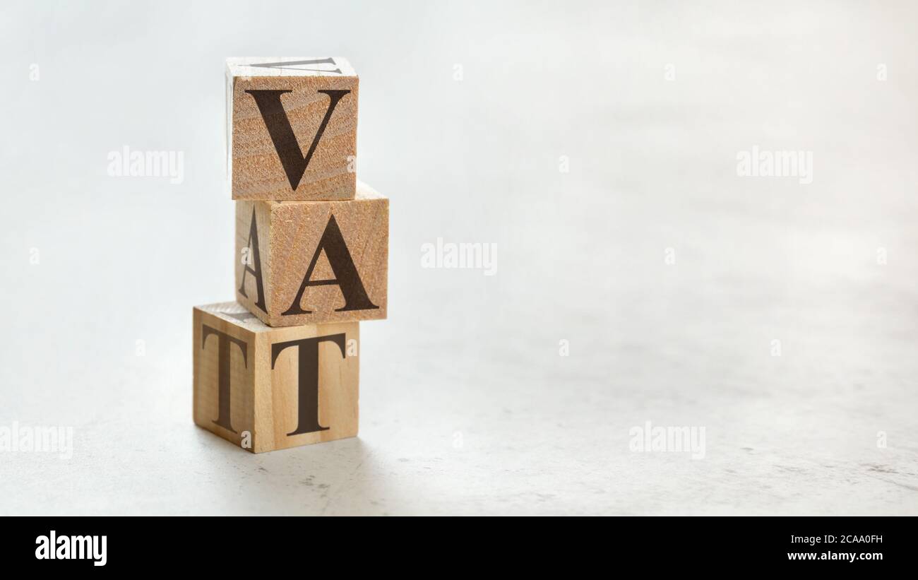 Pile avec trois cubes en bois - lettres TVA signifiant valeur ajoutée taxe sur eux, espace pour plus de texte / images sur le côté droit. Banque D'Images