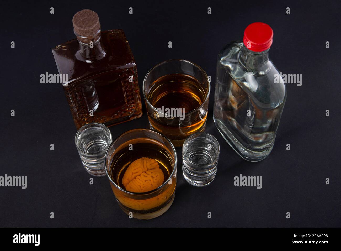 cerveau humain dans un verre avec une boisson alcoolisée, sur fond de bouteilles avec de l'alcool. Dépendance à l'alcool. Dommage au cerveau de l'alcool Banque D'Images