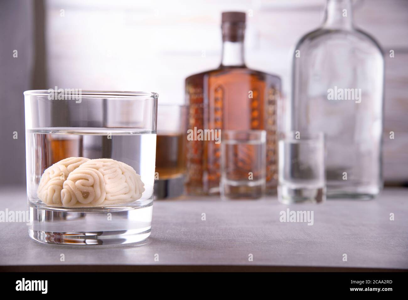 cerveau humain dans un verre avec une boisson alcoolisée, sur fond de bouteilles avec de l'alcool. Dépendance à l'alcool. Dommage au cerveau de l'alcool Banque D'Images