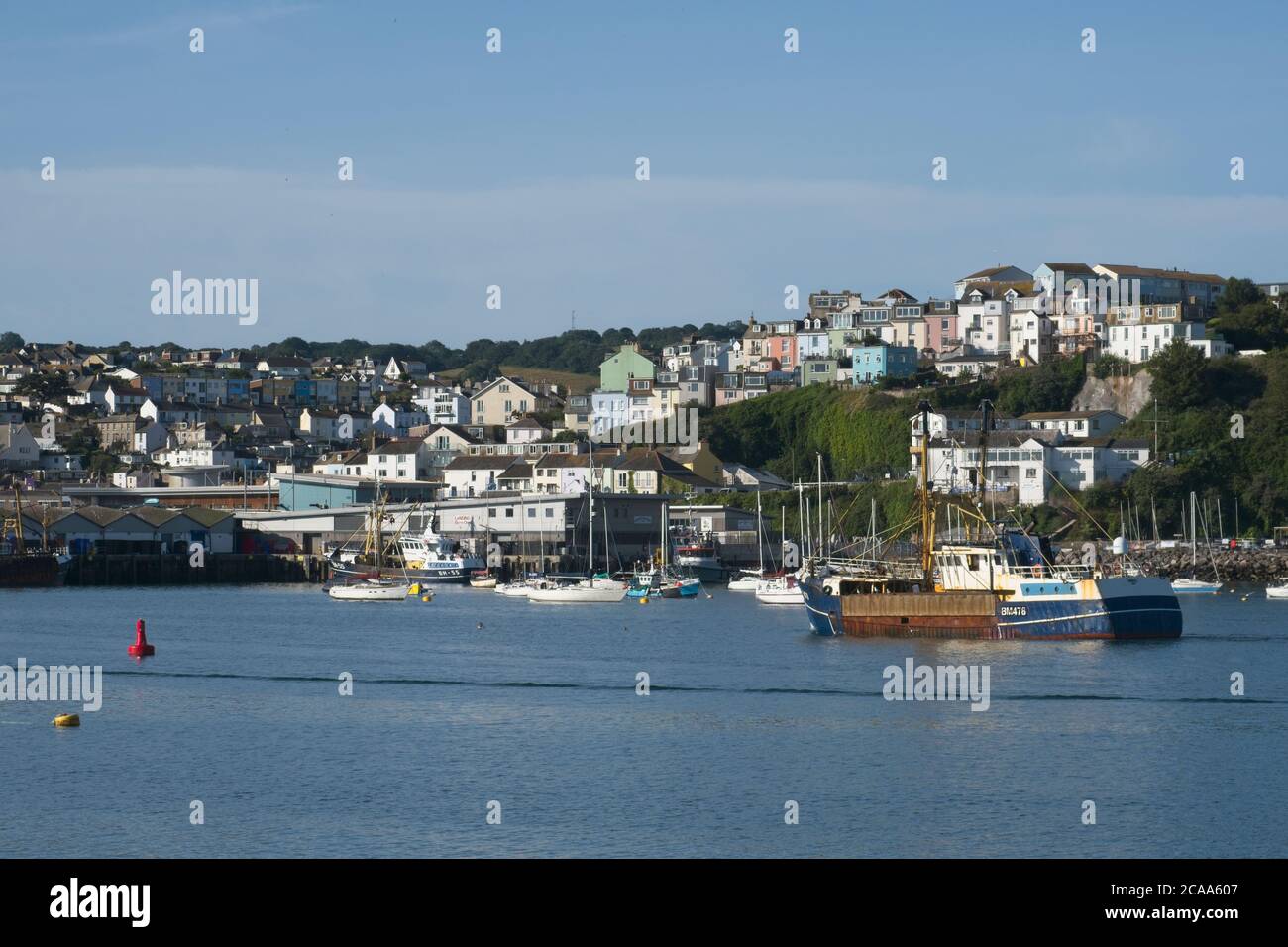 Brixham Trawler BM478 Danielle retourne au port chalutiers commerciaux manouvant Dans le port de Brixham calme mer lumière bleu ciel Tiered bâtiments derrière Banque D'Images