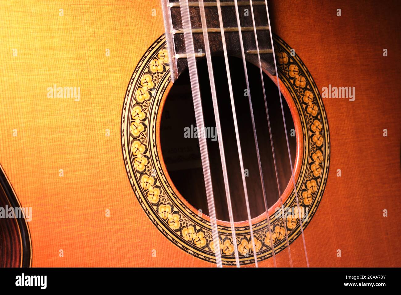 Gros plan de guitare acoustique avec cordes vibrantes. Cordes de guitare ondulées. Banque D'Images