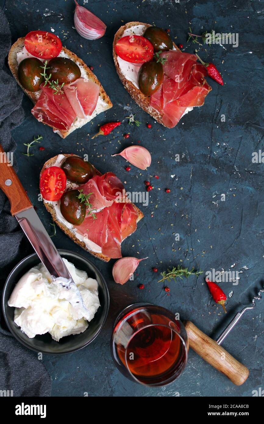 Set de bruschetta avec prosciutto, tomate et fromage clair pour le vin. Vue de dessus avec espace de copie. Banque D'Images