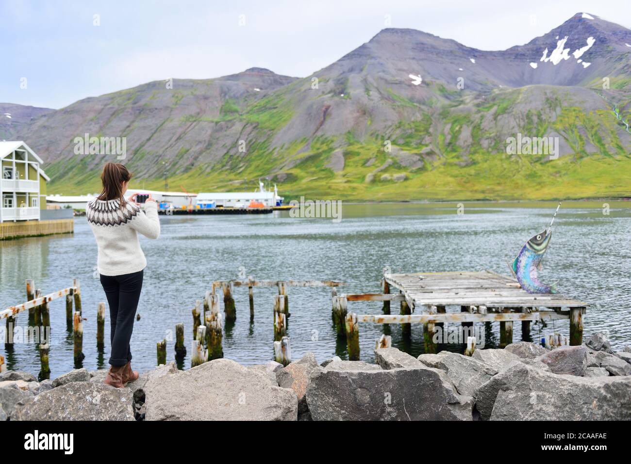 Tourisme sur l'Islande prendre une photo du fjord Siglufjordur portant un chandail islandais. Femme visitant l'islande à Siglufjordur ville de prendre Banque D'Images