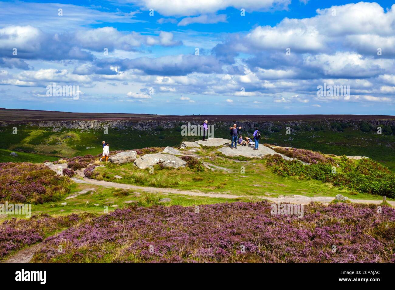 Groupe de familles sur Higgar Tor, la bruyère pourpre et saumâtre sur les landes de la vallée de Burbage, Parc national de Peak District, Derbyshire Banque D'Images