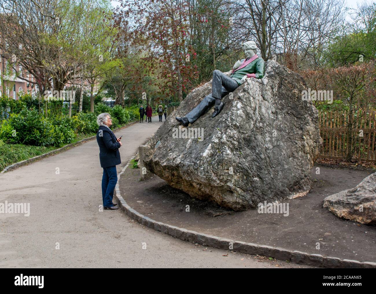 Lady regardant la statue d'Oscar Wilde à Merrion Square à Dublin Irlande Banque D'Images