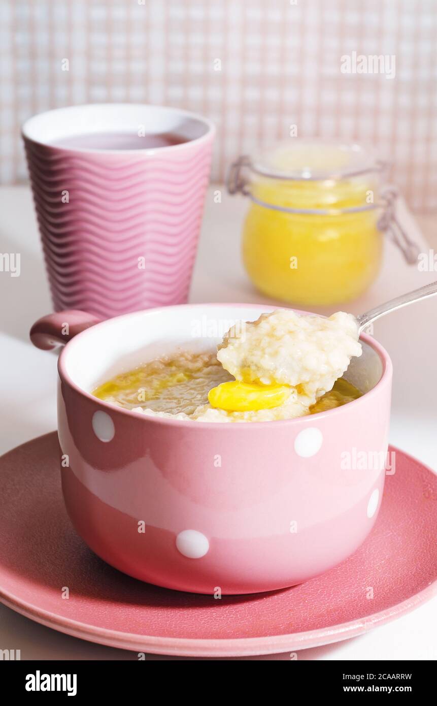 Porridge de flocons d'avoine pour le petit déjeuner avec beurre et miel. Nourriture végétalienne, petit déjeuner sain Banque D'Images