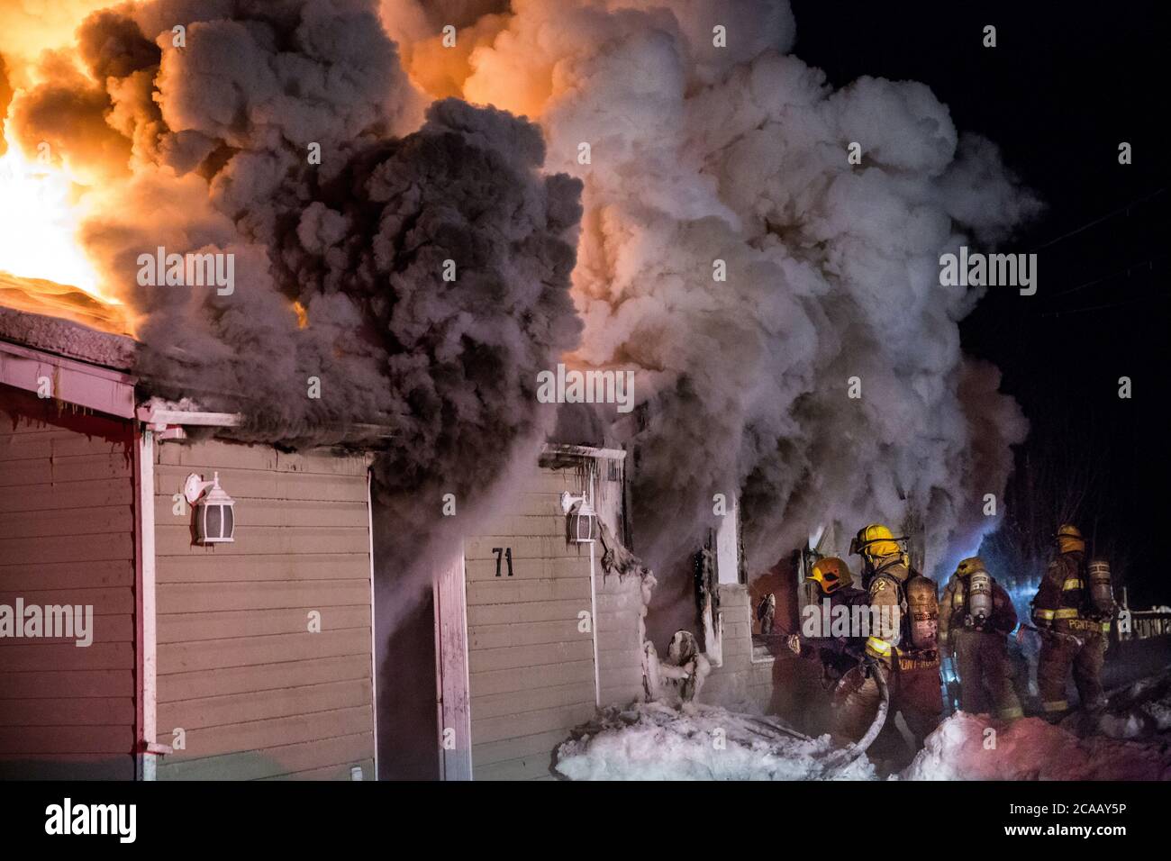 Feu de maison avec une flamme intense et un nuage de fumée noire. Banque D'Images