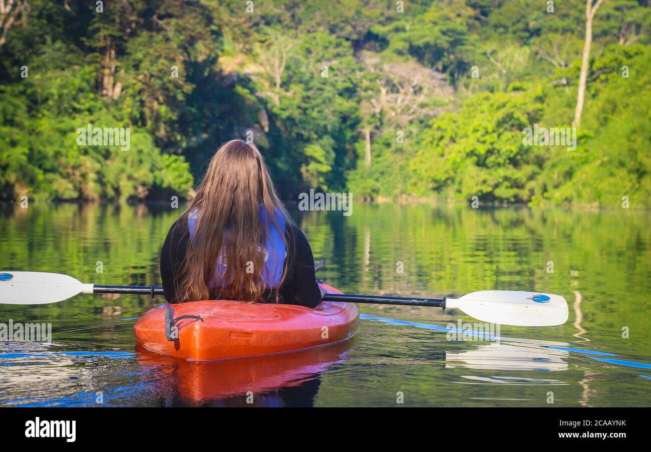 PUNTA GORDA, BELIZE - 16 février 2019 : une jeune femme se pagaie le long de la rivière Moho au milieu de la jungle du sud du Belize. Banque D'Images