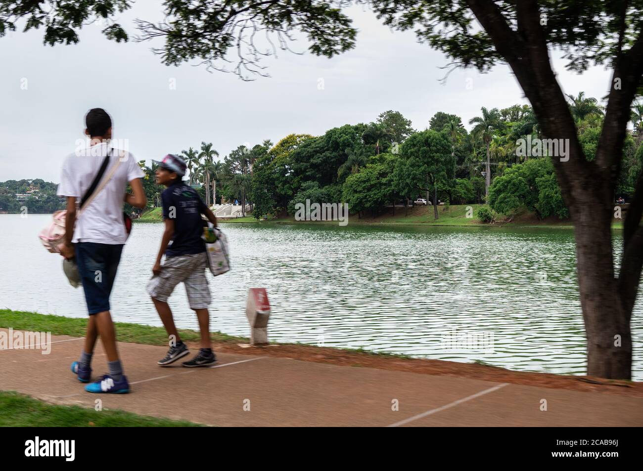 Vue partielle sur le lac calme Pambumha avec sa végétation verte près du parc d'attractions Guanabara, sous ciel couvert d'été. Banque D'Images