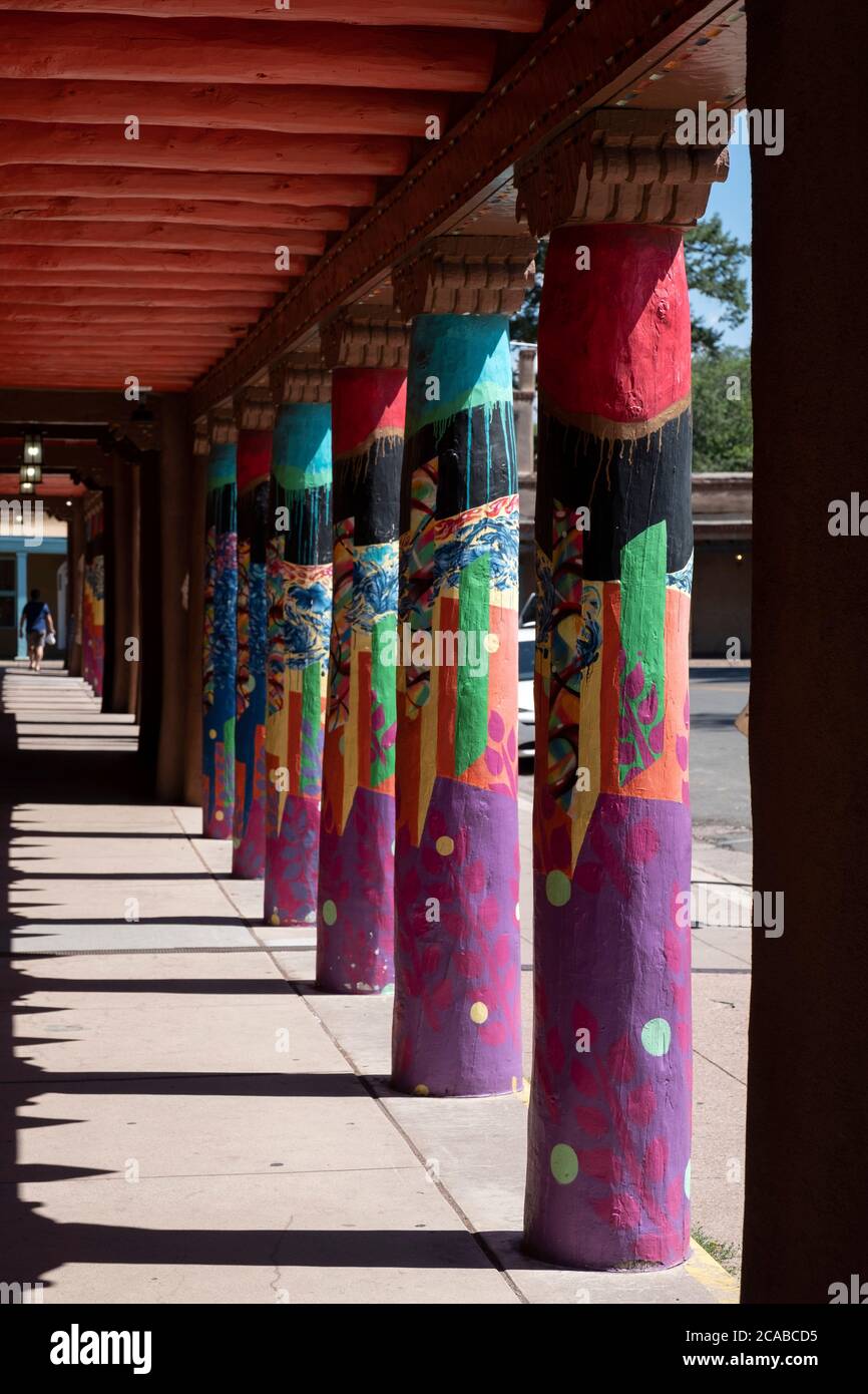 Colonnes colorées le long d'un trottoir couvert dans le centre-ville historique de Santa Fe, Nouveau-Mexique Banque D'Images