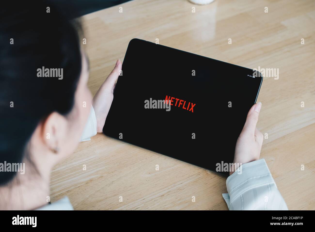 CHIANG MAI, THAÏLANDE, 26 JUILLET 2020 : une femme tient la main d'une tablette intelligente avec le logo Netflix sur un iPad d'Apple. Netflix est un fournisseur mondial de films en streaming Banque D'Images