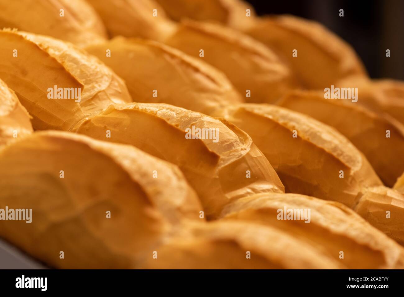 croquant le pain de baguette en croûte sur le détail de la grille Banque D'Images