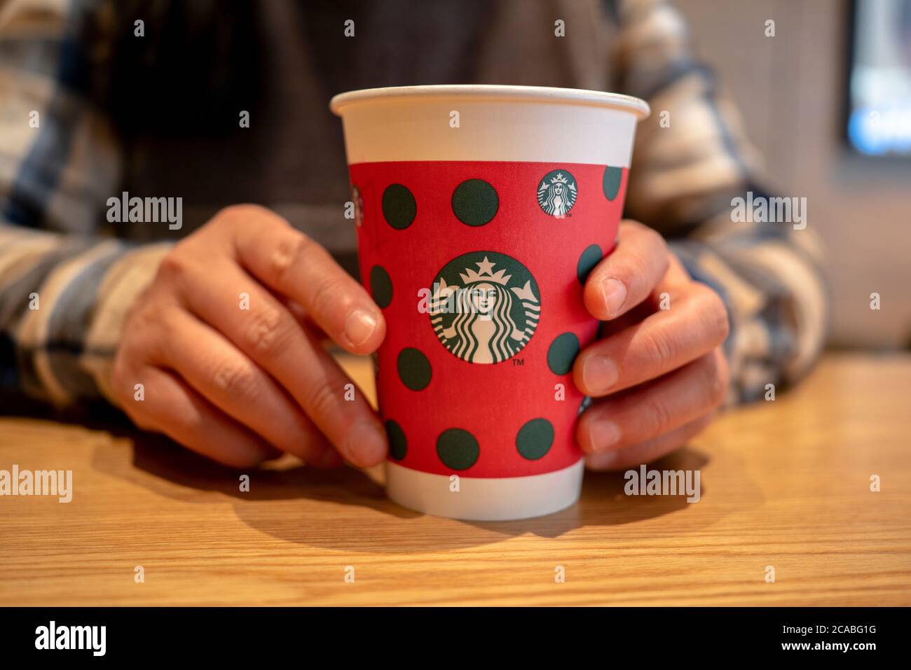Tasse en papier de Noël sur table dans un café Starbucks. Banque D'Images