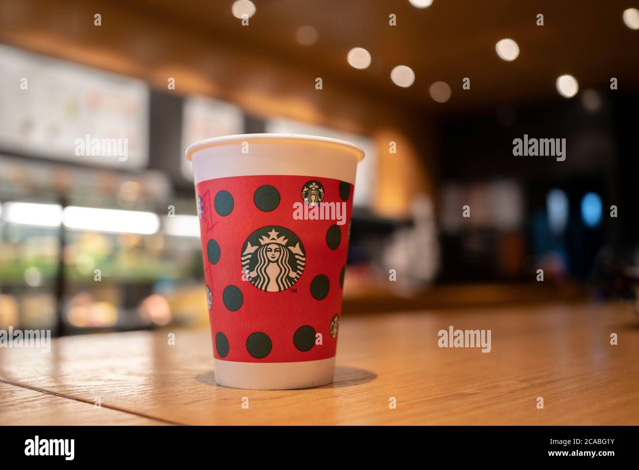 Tasse en papier de Noël sur table dans un café Starbucks. Banque D'Images