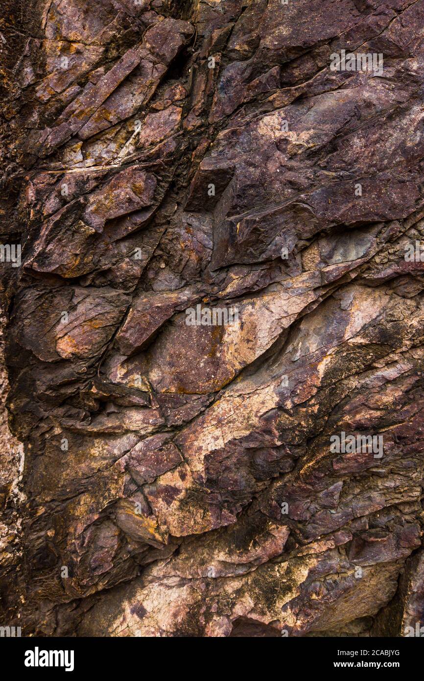 Gros plan des fissures sombres de la falaise de la rade. Texture roche en pierre grise des montagnes. Concept de géologie et d'alpinisme Banque D'Images