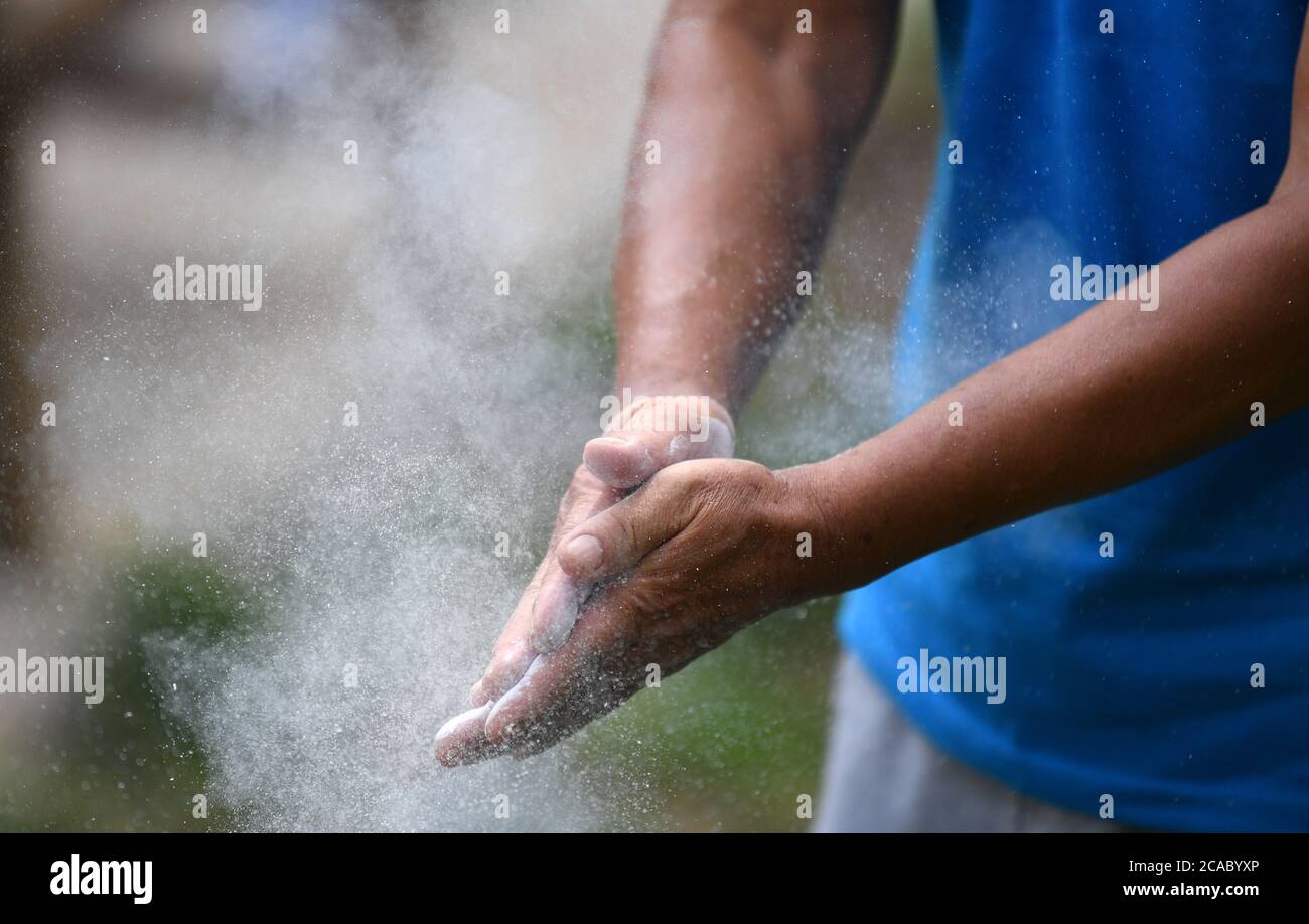 (200806) -- TIANJIN, le 6 août 2020 (Xinhua) -- une personne âgée frotte de la poudre dans ses mains avant de faire de l'exercice au parc Xigu, dans le nord de la Chine, Tianjin, le 4 août 2020. Un groupe de personnes âgées a formé une équipe de gymnastique à Tianjin il y a dix ans. Ils ont pratiqué régulièrement comme exercice physique quotidien. L'équipe compte maintenant plus de 20 membres, avec une moyenne d'âge de 68 ans. « l'exercice nous permet de maintenir un bon état physique, ce qui est très utile pour améliorer la qualité de vie. » a déclaré Tong Yugen, le chef d'équipe âgé de 66 ans. À mesure que l'équipe devient de plus en plus connue, plus de 100 amateurs de fitness les ont rejoints dans l'exercice de la veille Banque D'Images