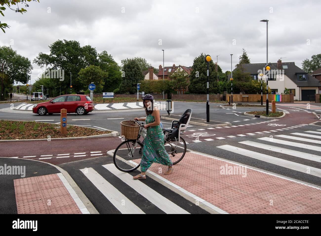 Une femme utilise le passage piéton sur le premier rond-point de style hollandais du Royaume-Uni, qui donne la priorité aux cyclistes et aux piétons sur les automobilistes, après son ouverture sur Fendon Road, Cambridge. Le coût du projet, estimé à l'origine à environ 800,000 GBP, a presque triplé à 2,3 millions de GBP à la fin du projet. Banque D'Images
