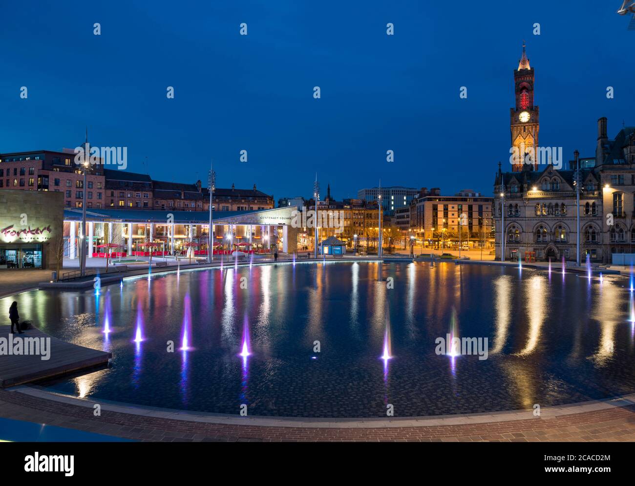 Vue en soirée sur l'hôtel de ville, la piscine miroir et les fontaines du parc Bradford City Park Banque D'Images
