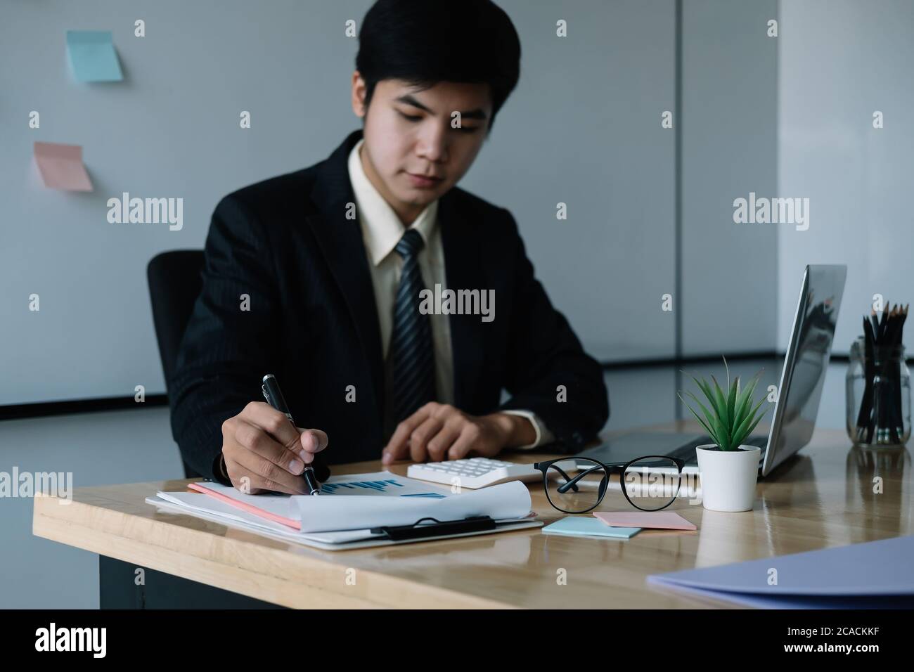 Homme d'affaires asiatique travaillant avec un ordinateur portable pour la finance au bureau Banque D'Images