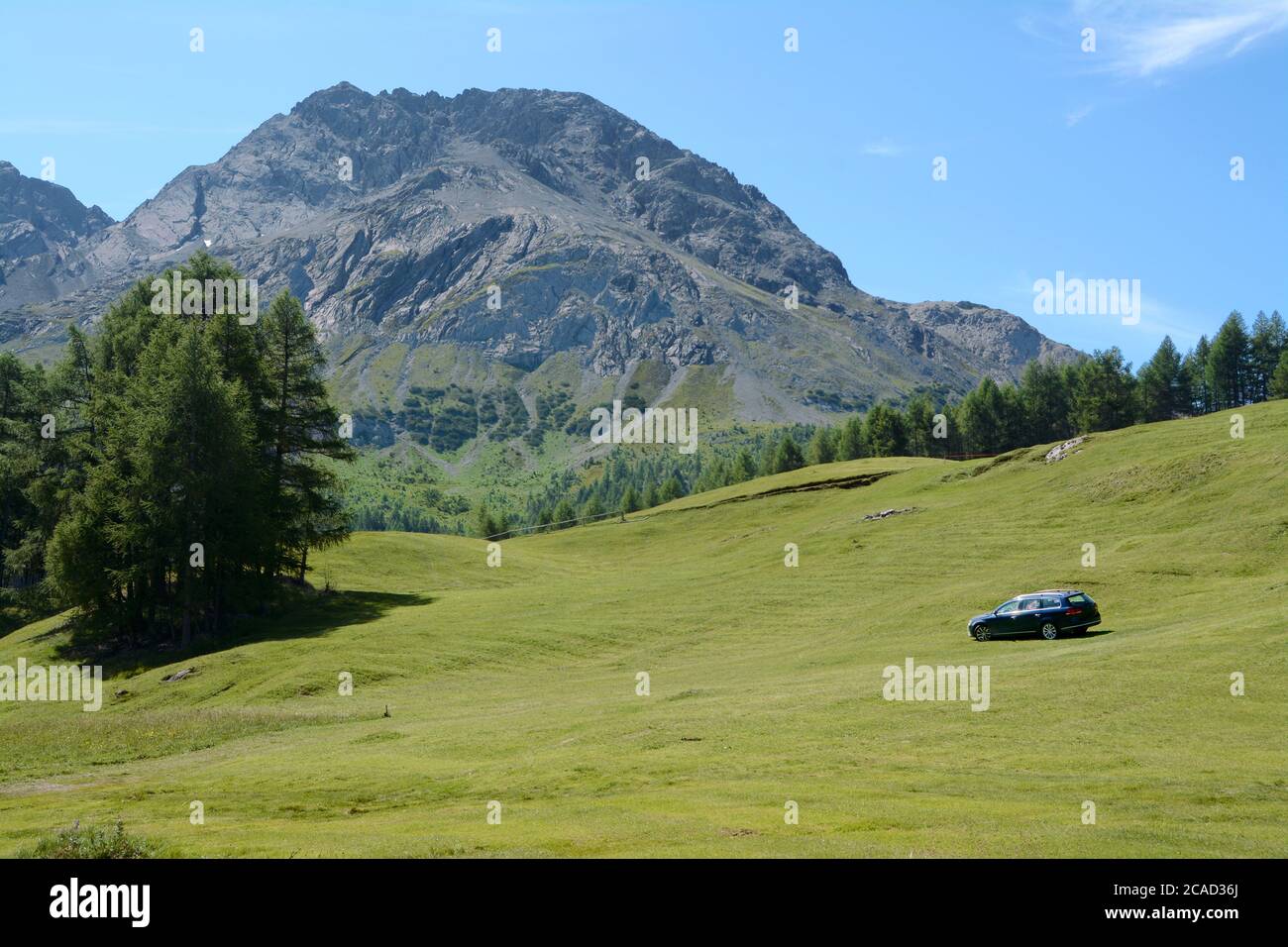 Voiture sur un pré de montagne près du lac Cancano dans les Alpes Lombardie. Banque D'Images