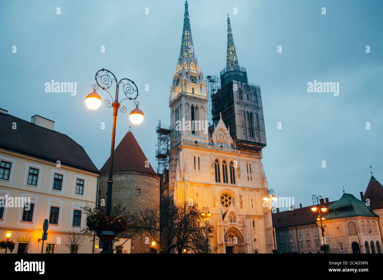 Une vue latérale de la cathédrale de Zagreb d'un angle bas vers le haut et avec l'une des tours en cours d'entretien dans un après-midi nuageux. Banque D'Images