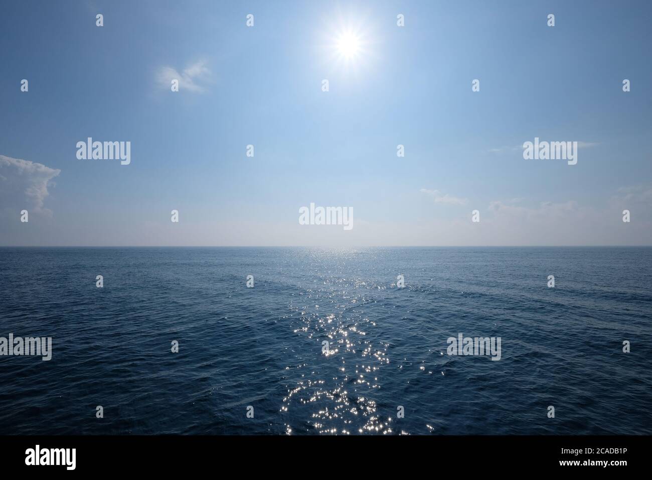 large horizon marin bleu profond. Soleil éclatant dans le ciel bleu. océan avec reflet de la lumière du soleil Banque D'Images