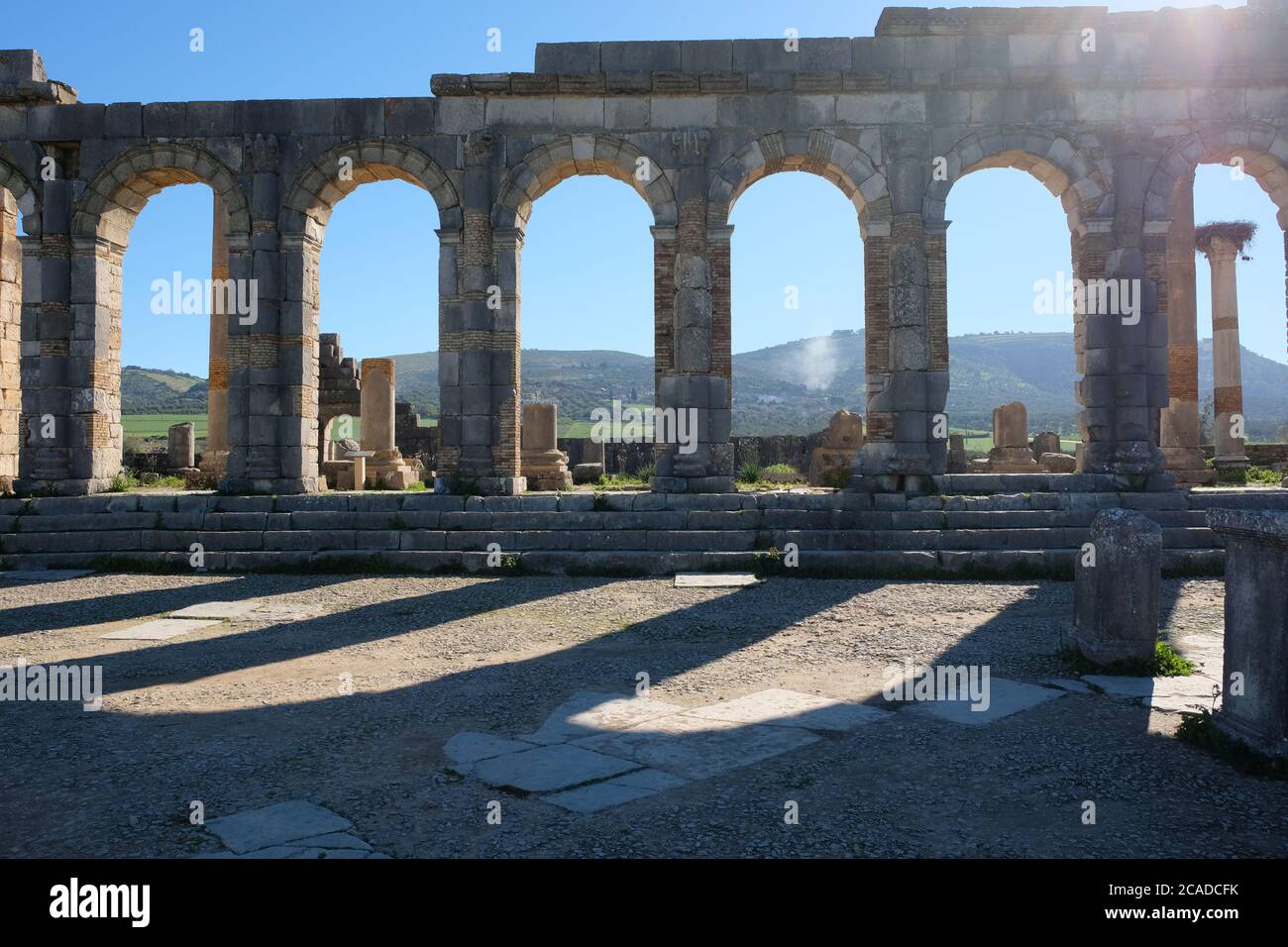 Façade des anciennes arcades romaines sous le soleil à volubilis en Morocoo. Magnifiques ruines de briques en pierre de la capitale romaine Banque D'Images