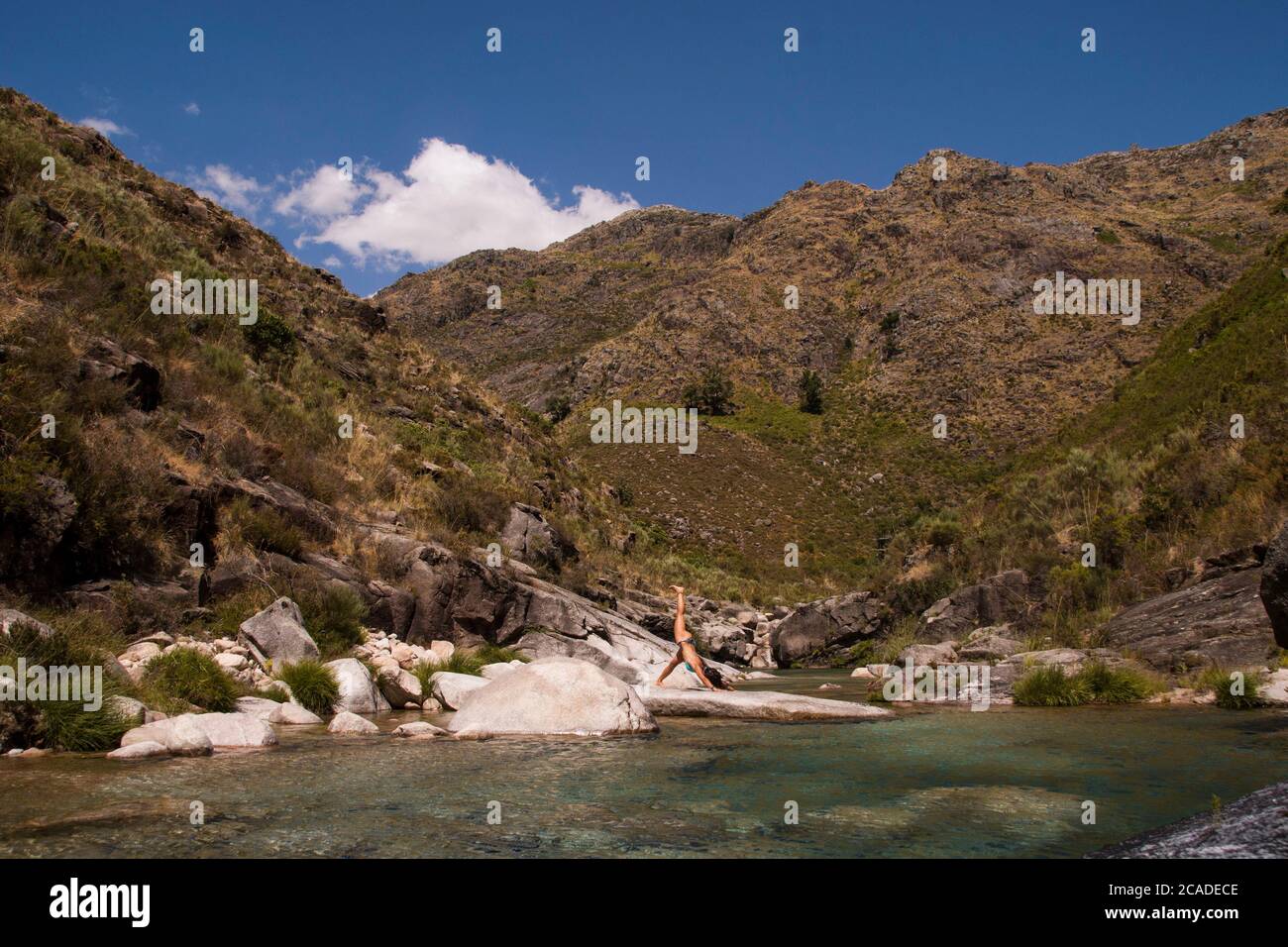 Pose de yoga sur une rive de lac entourée de montagnes. Environnement immaculé Banque D'Images