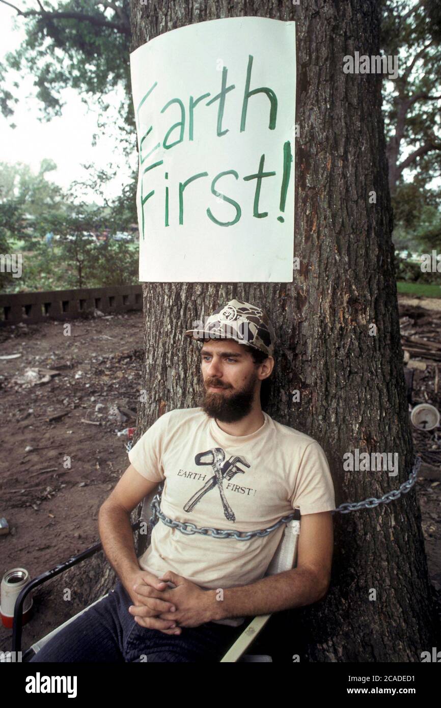 Austin Texas USA, ©1990 : la Terre d'abord ! un activiste enchaîné à un arbre pour empêcher l'équipe des travaux publics de le raser au bulldozer dans le cadre d'un projet de lutte contre les inondations qui élargit les cours d'eau dans un quartier à faible revenu. ©Bob Daemmrich Banque D'Images