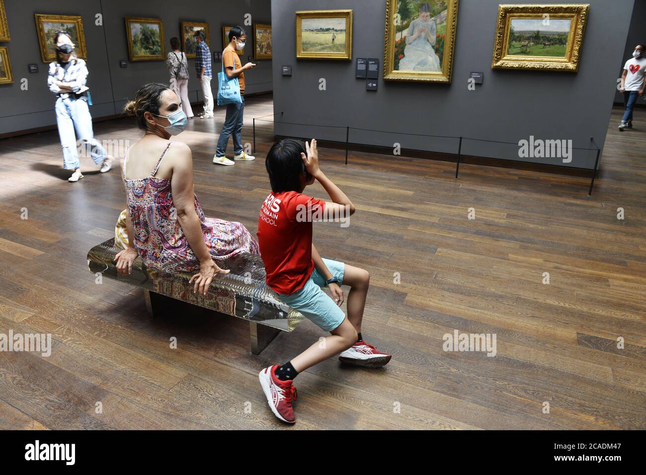 Visiteurs contemplant l'art impressionniste et post-impressionniste à l'intérieur du Musée d'Orsay à Paris, France Banque D'Images