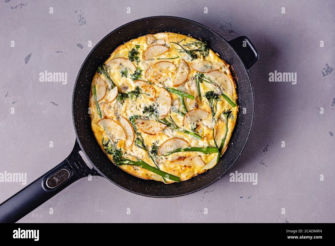 Frittata aux œufs cuits au fromage et broccolini sur table grise Banque D'Images