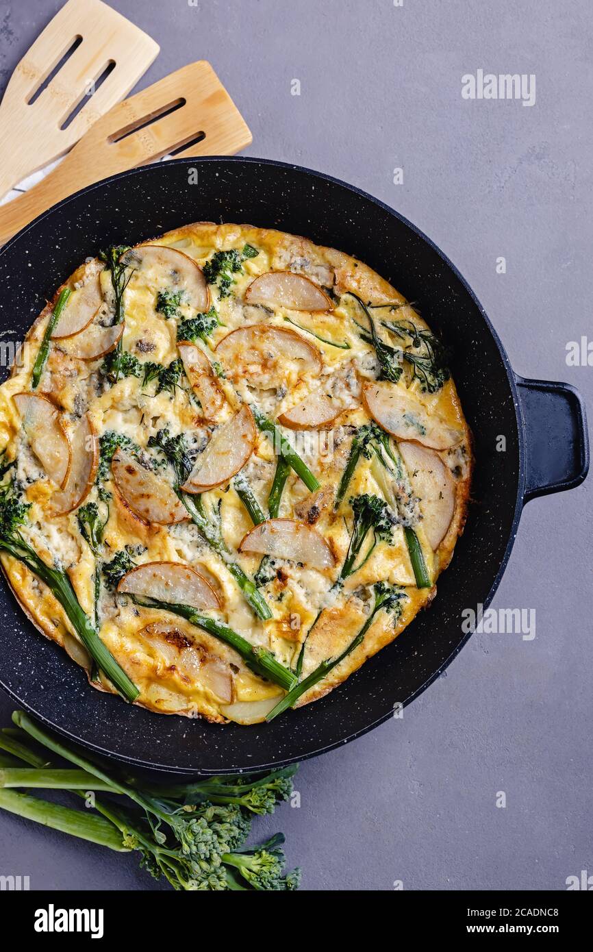 Frittata aux œufs cuits au fromage et broccolini sur table grise Banque D'Images