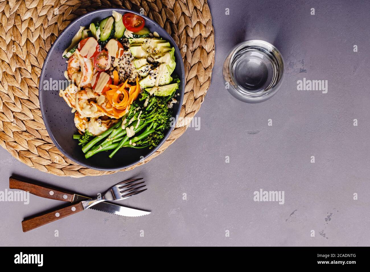 Bol avec quinoa, crevettes, avocat et broccolini. Banque D'Images