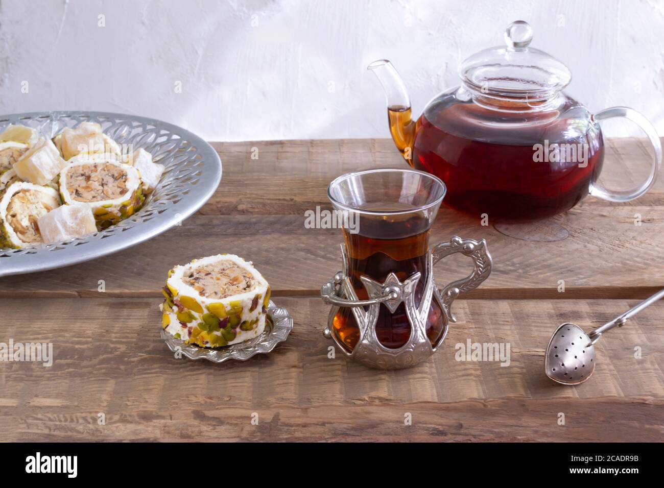 Thé turc dans une tasse traditionnelle sur une table en bois. Thé avec des sucreries orientales et une boisson parfumée. Banque D'Images