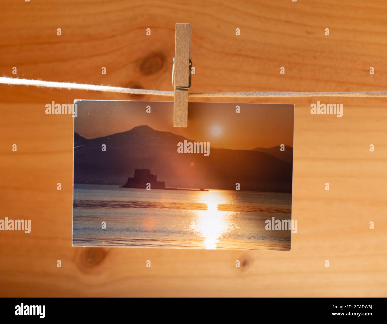 Belles photos accrochées avec des épingles à linge sur fond en bois Banque D'Images