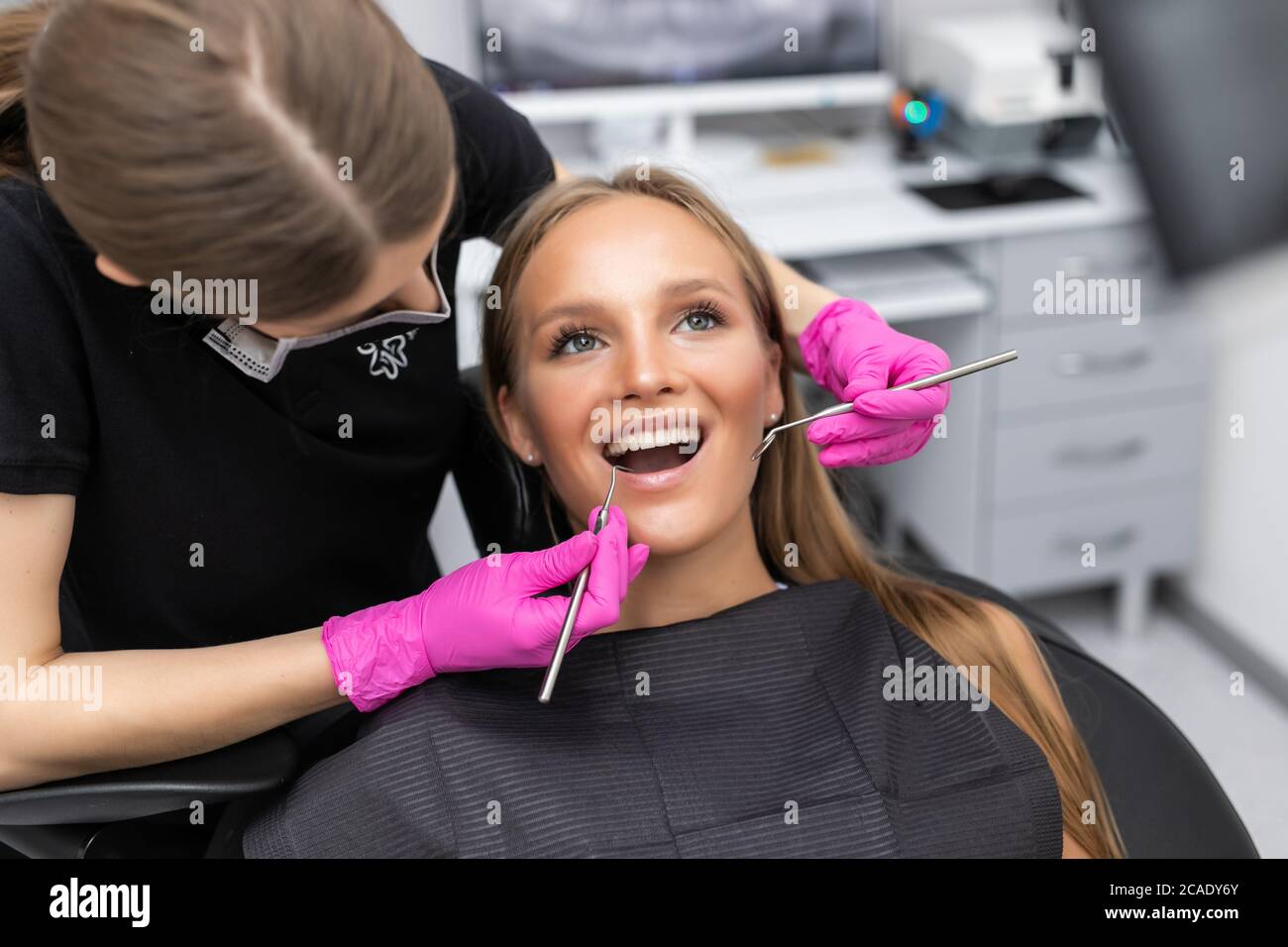 Belle femme besoin de soins dentaires du patient au cabinet du dentiste. Banque D'Images