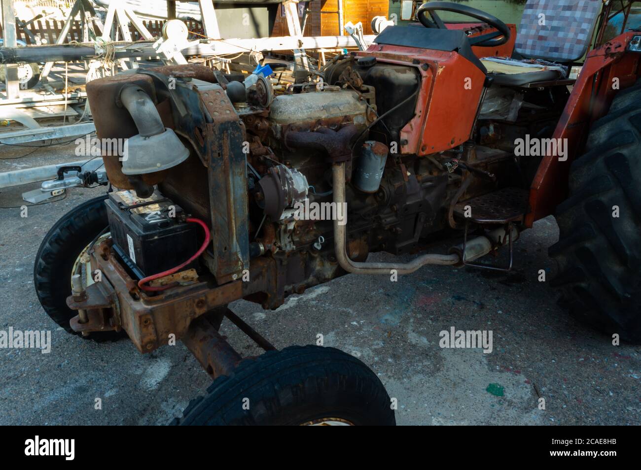 tracteur rouge rouillé avec moteur découvert en gros plan Banque D'Images