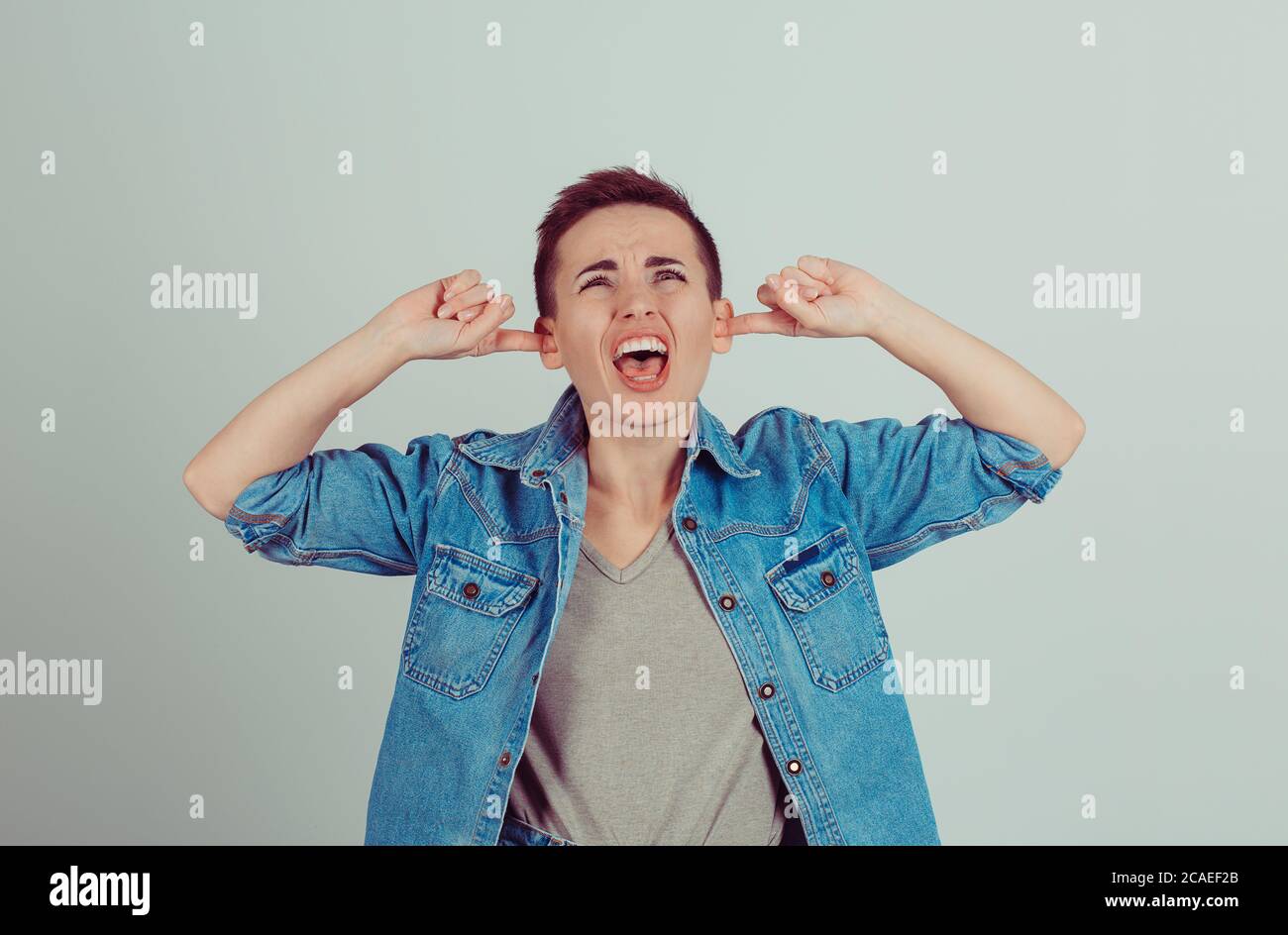 Portrait Young Woman Screaming Malheureux A Souligné Ses Oreilles Jusqu'à  Cesser De Faire Crier Le Bruit, Elle Me Donne Des Maux De Tête Vert Clair  Isolé Wa Photo Stock - Alamy