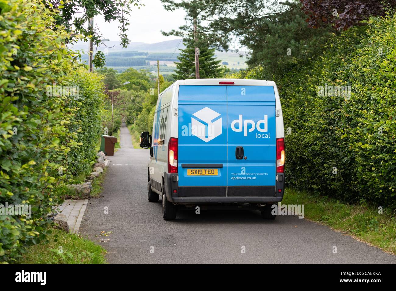 camionnette de livraison locale dpd effectuant la livraison dans un village rural, en Écosse, au Royaume-Uni Banque D'Images