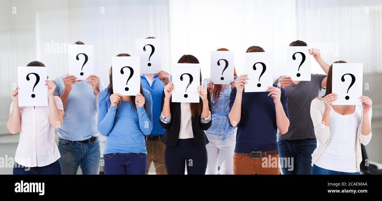 Groupe d'étudiants confus tenant des signes de question mystère Banque D'Images